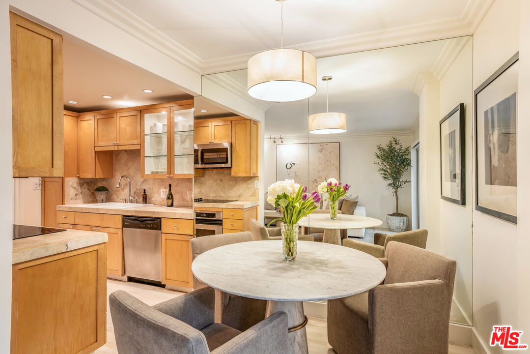 1131 Alta Loma Road, Unit 116 West Hollywood, CA 90069 - Photo 7 of 25 a kitchen with kitchen island a sink dining table and chairs