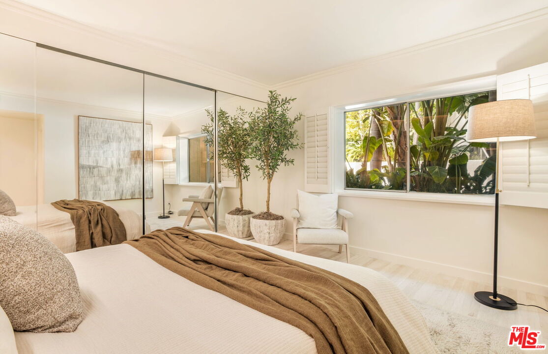 1131 Alta Loma Road, Unit 116 West Hollywood, CA 90069 - Photo 9 of 25 a bedroom with a large bed and a lamp next to a window