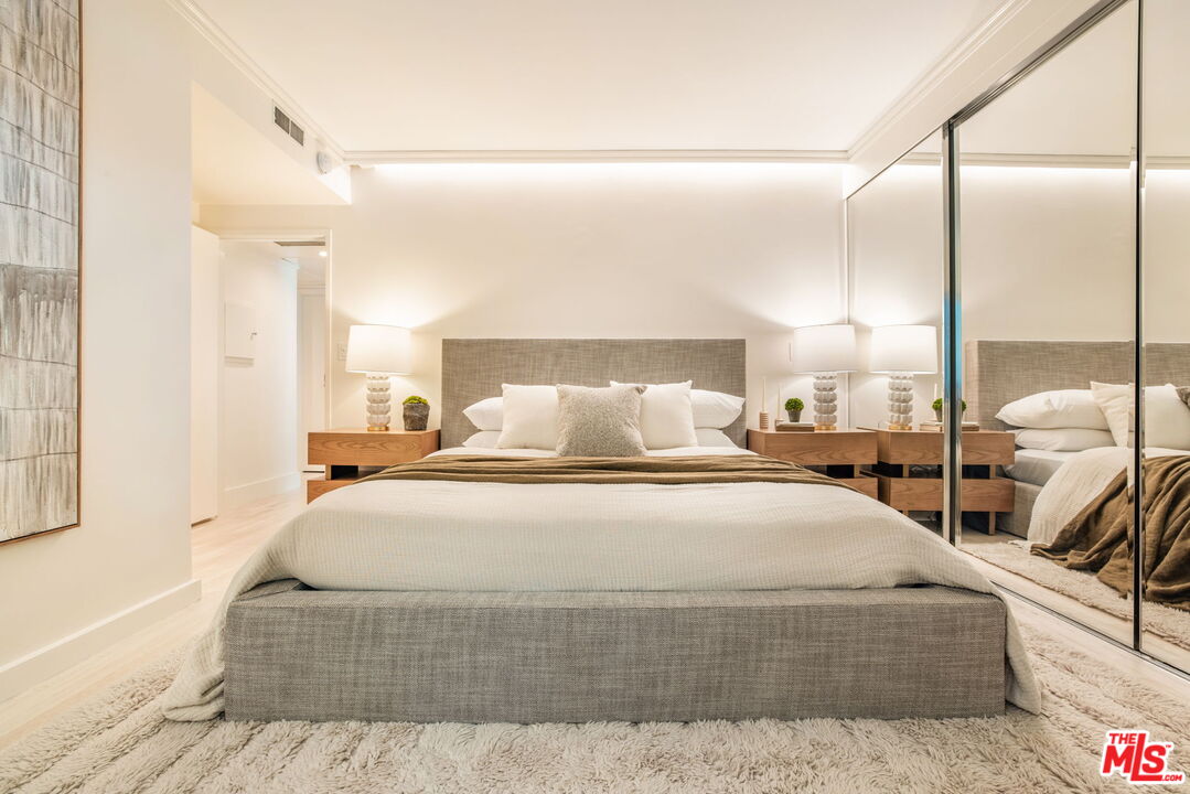 1131 Alta Loma Road, Unit 116 West Hollywood, CA 90069 - Photo 10 of 25 a large bedroom with a large bed and a chandelier