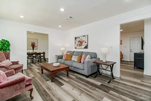 a living room with furniture and a wooden floor