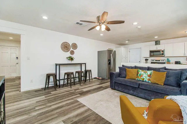 a living room with furniture and kitchen view