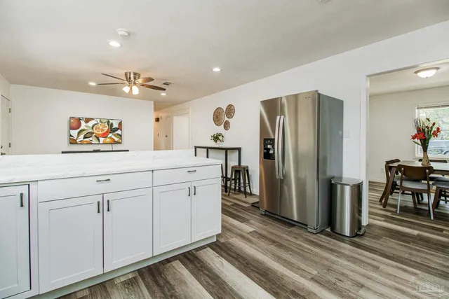 a kitchen with stainless steel appliances white cabinets and wooden floors