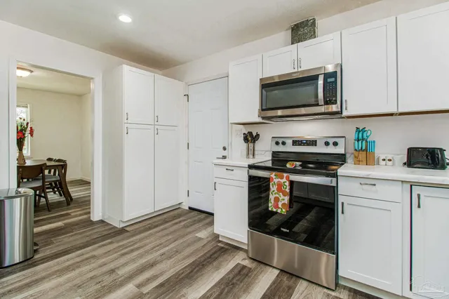 a kitchen with stainless steel appliances a stove a microwave and cabinets