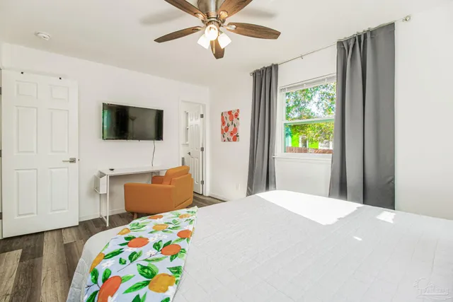 a bedroom with a bed a window and a flat screen tv