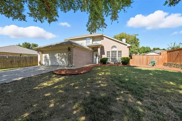 a view of a house with a big yard plants and large trees