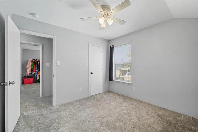 an empty room with a window and a fan