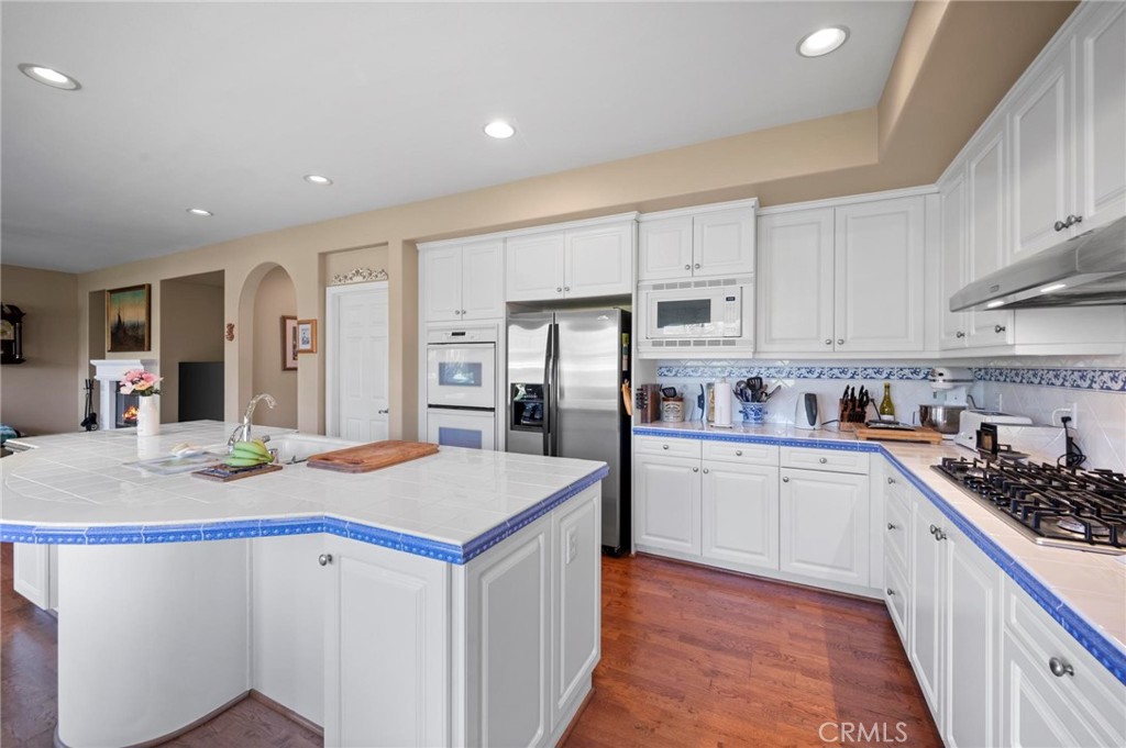 3262 Bluebird Circle Simi Valley, CA 93063 - Photo 14 of 43 a kitchen that has a lot of white cabinets and stainless steel appliances