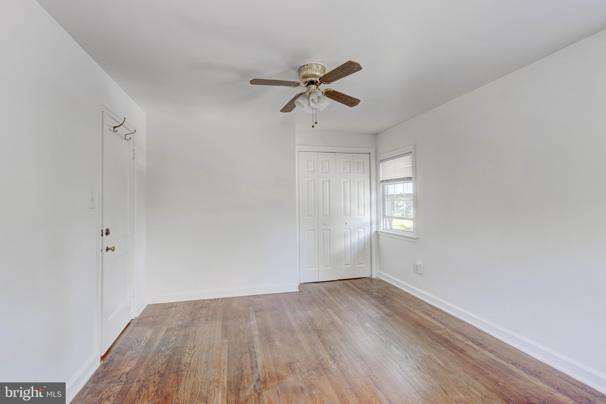 523 Academy Road Catonsville, MD 21228 - Photo 14 of 26 an empty room with wooden floor ceiling fan and windows