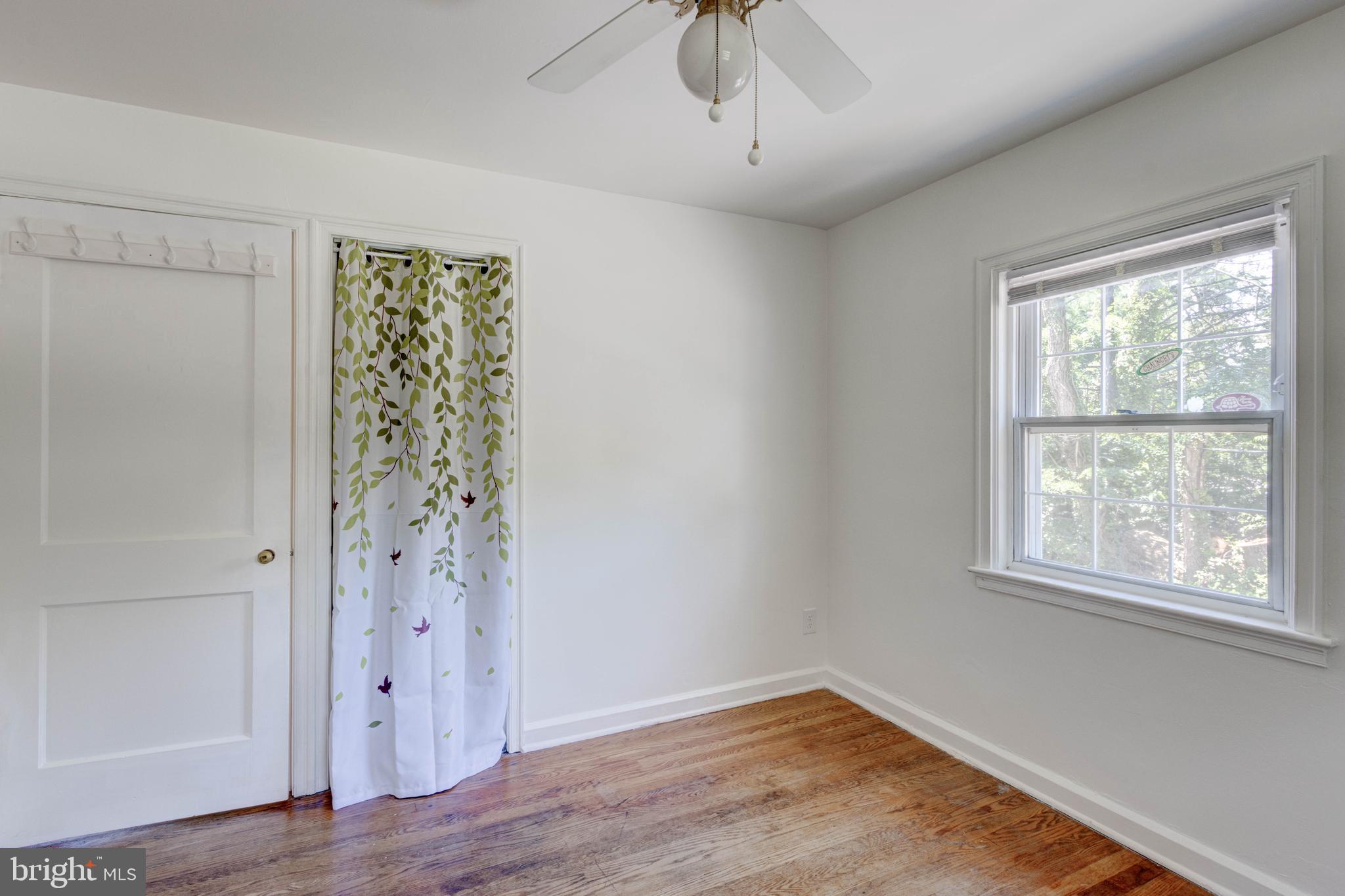 523 Academy Road Catonsville, MD 21228 - Photo 16 of 26 an empty room with wooden floor chandelier fan and windows