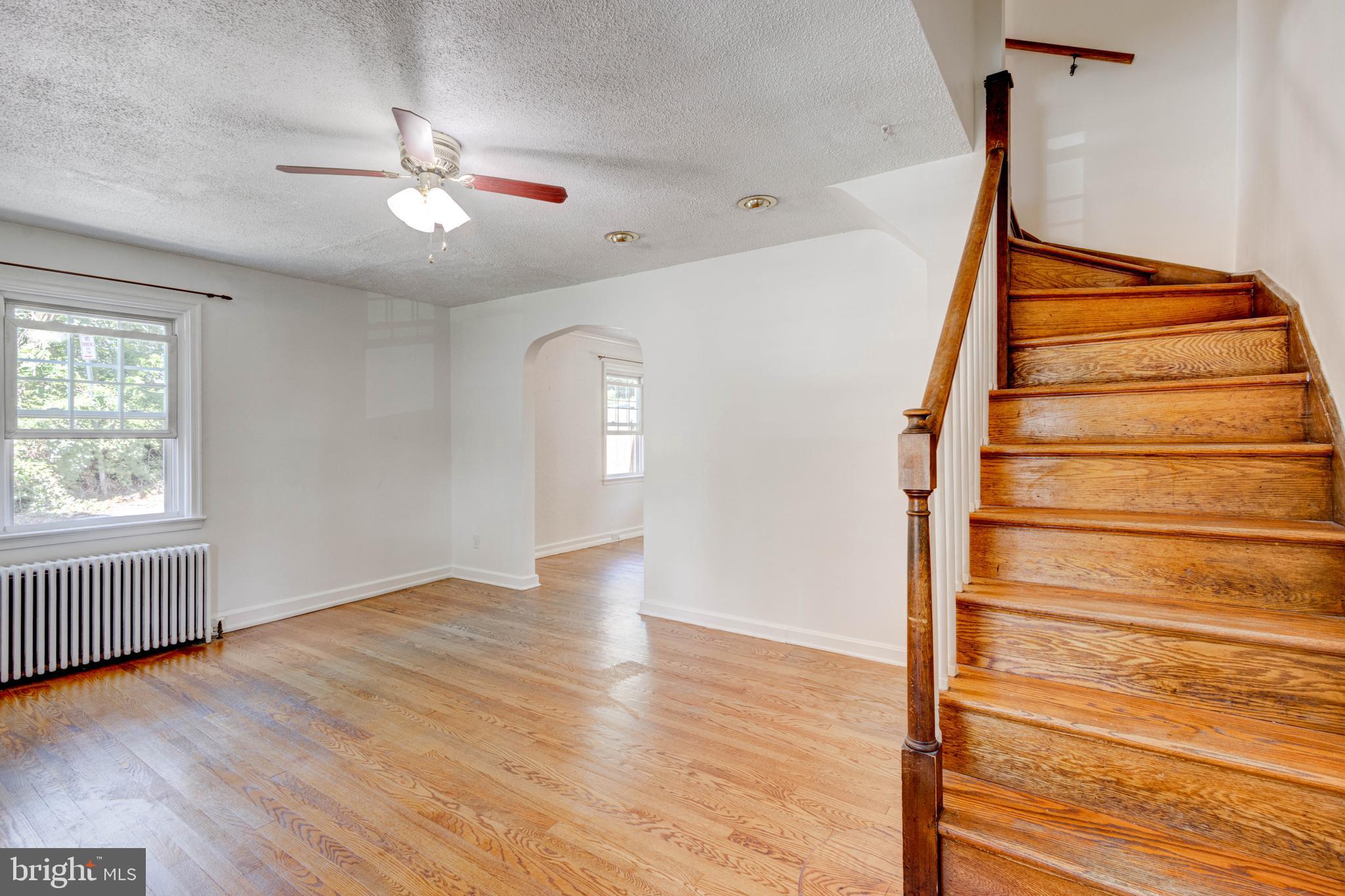523 Academy Road Catonsville, MD 21228 - Photo 3 of 26 an empty room with wooden floor fan and windows