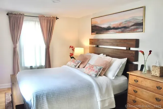 a bedroom with a bed and a painting on the wall