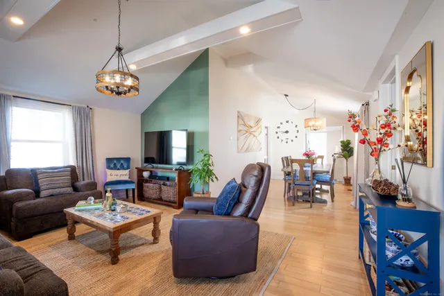 a living room with furniture chandelier and a flat screen tv