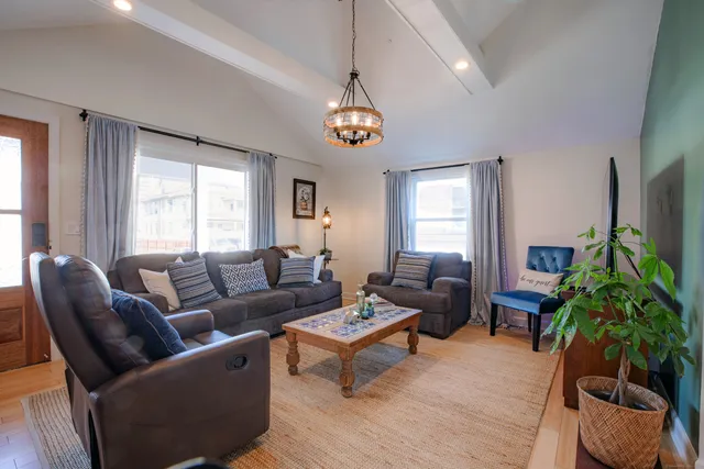 a living room with furniture a chandelier and a window