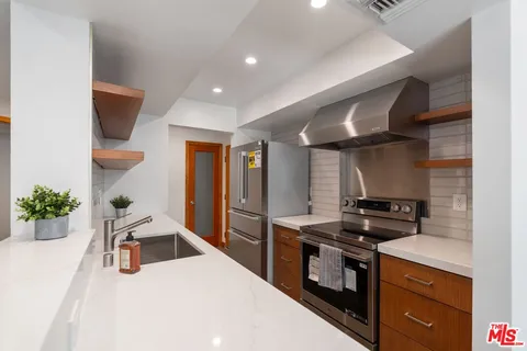 a bathroom with a granite countertop sink a mirror and shower
