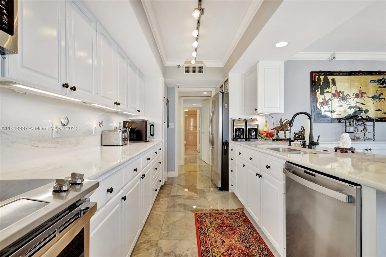 5380 North Ocean Drive, Unit 22J Riviera Beach, FL 33404 - Photo 31 of 83 a large kitchen with stainless steel appliances kitchen island granite countertop a sink and cabinets
