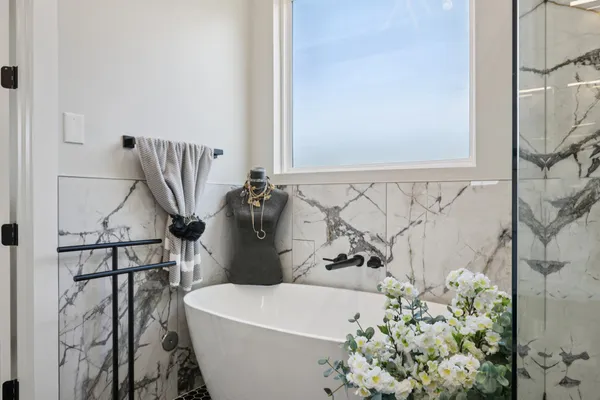 a white bath tub sitting next to a white sink and vanity