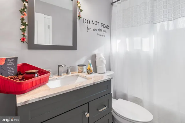 a bathroom with a sink toilet vanity and tub