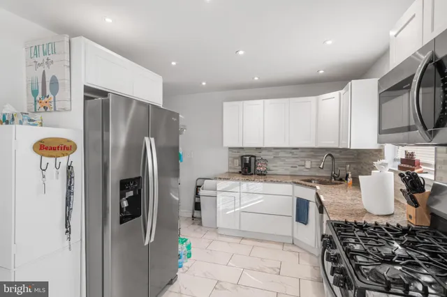a kitchen with stainless steel appliances a refrigerator sink and cabinets