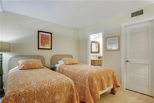a bedroom with two beds and painting on the wall