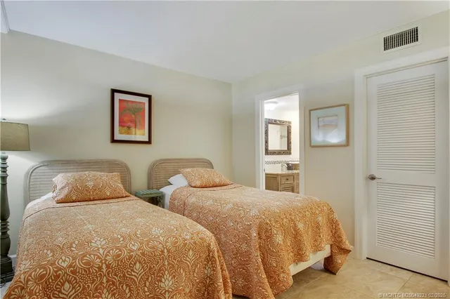 a bedroom with two beds and painting on the wall