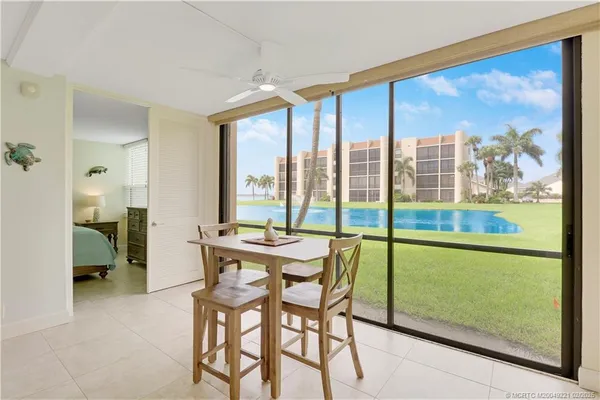 a dining room with furniture and a floor to ceiling window