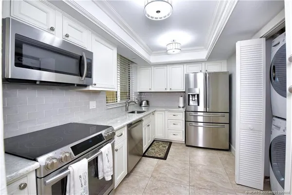 a kitchen with stainless steel appliances granite countertop a stove microwave sink and refrigerator