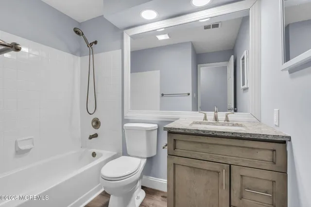 a bathroom with a granite countertop toilet sink and mirror