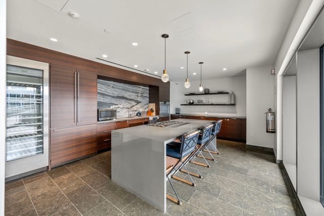 a kitchen with kitchen island a stove a counter space a sink and a refrigerator