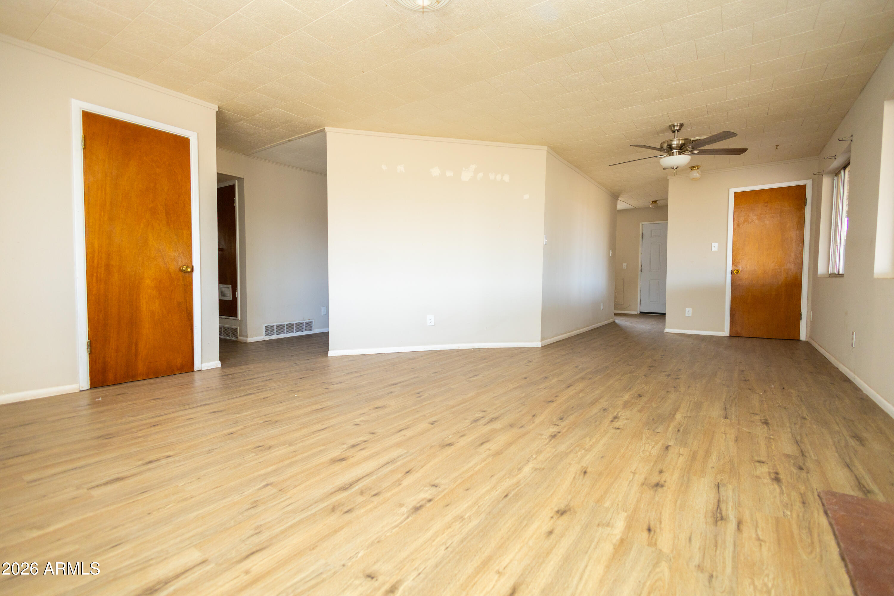 1626 11th Street Douglas, AZ 85607 - Photo 10 of 30 an empty room with wooden floor and windows