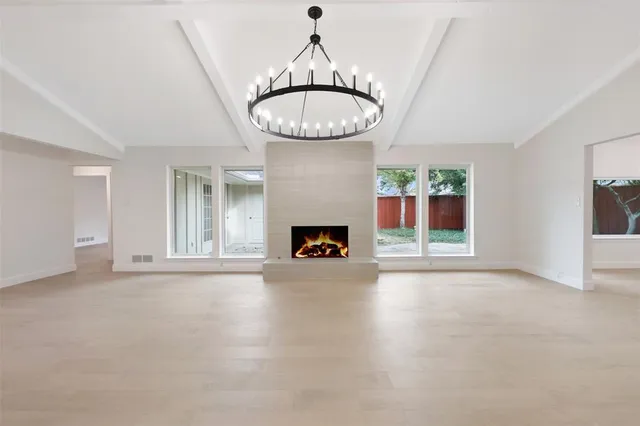 a view of an empty room with a fireplace and window