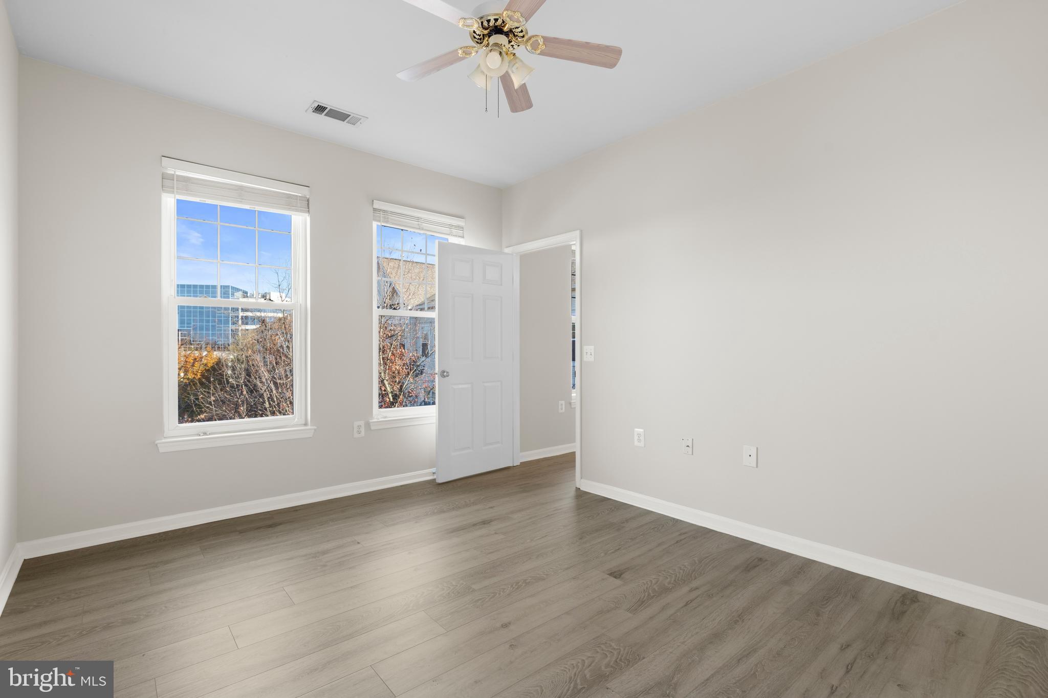 3851 Aristotle Court, Unit 1402 Fairfax, VA 22030 - Photo 14 of 31 an empty room with wooden floor chandelier fan and windows