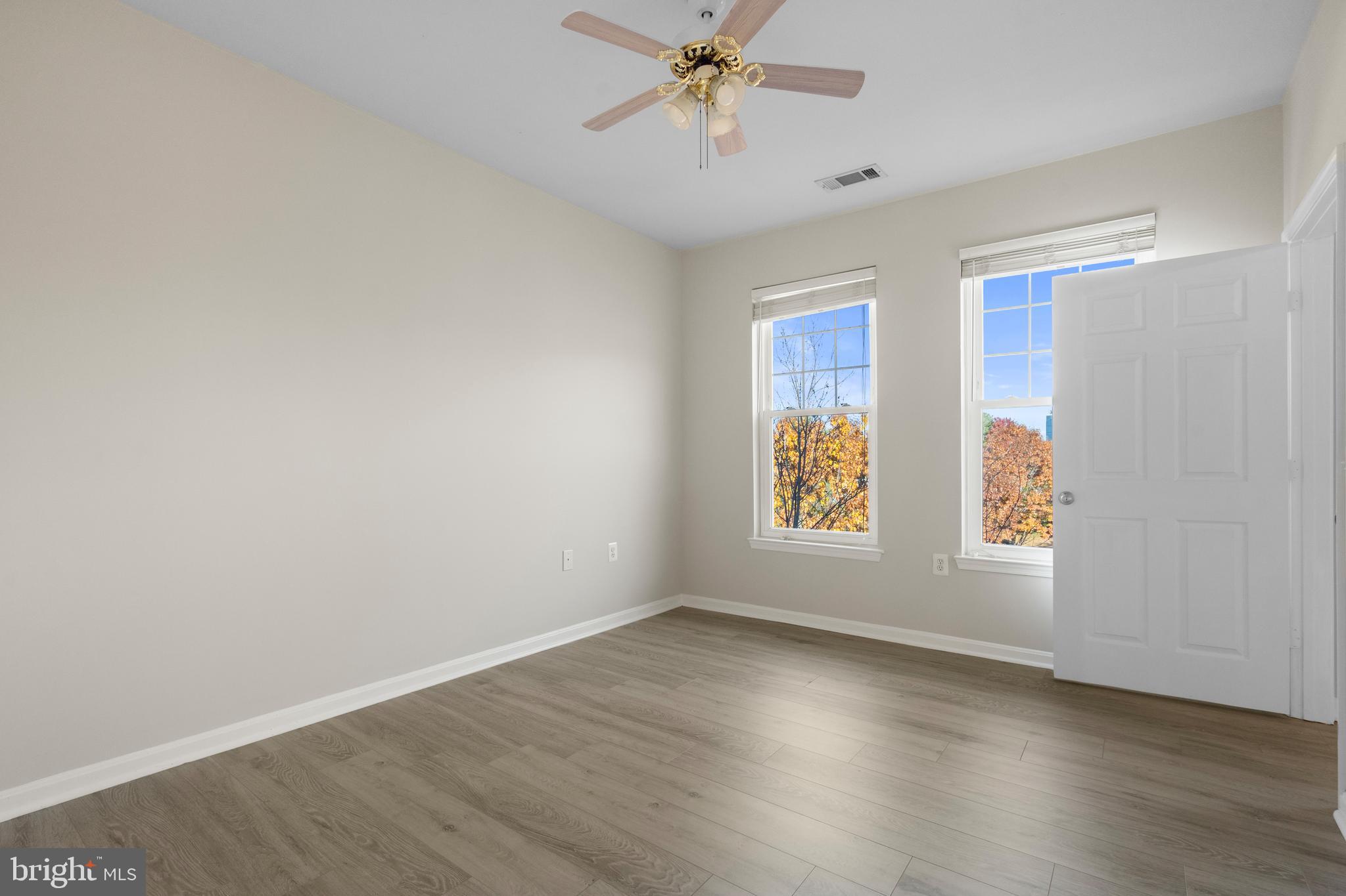 3851 Aristotle Court, Unit 1402 Fairfax, VA 22030 - Photo 16 of 31 an empty room with wooden floor fan and windows
