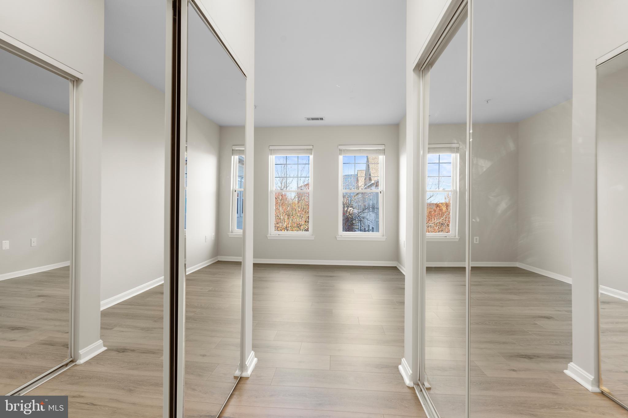 3851 Aristotle Court, Unit 1402 Fairfax, VA 22030 - Photo 26 of 31 a view of an empty room with window and wooden floor