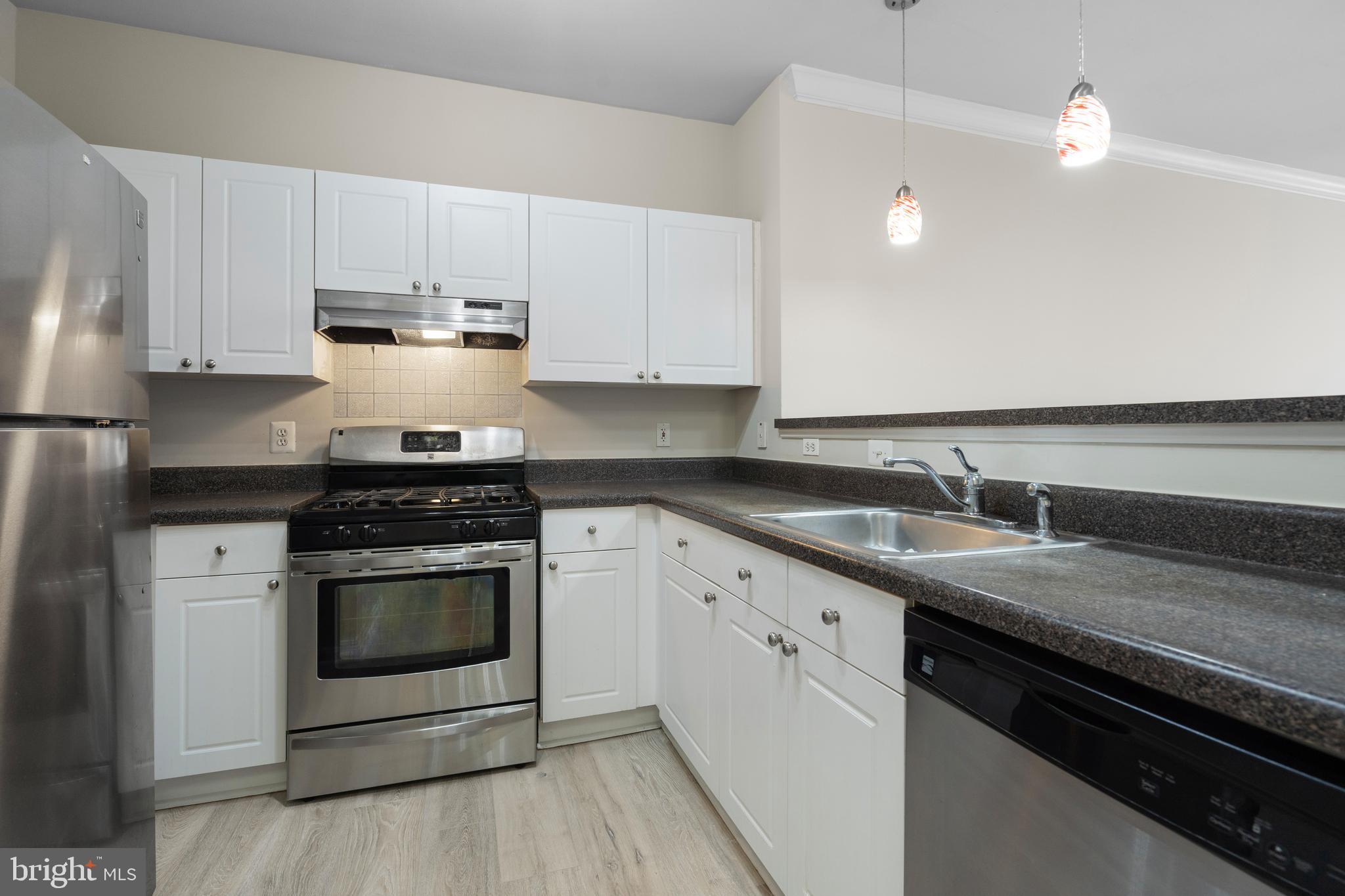 3851 Aristotle Court, Unit 1402 Fairfax, VA 22030 - Photo 9 of 31 a kitchen with granite countertop a stove sink and cabinets