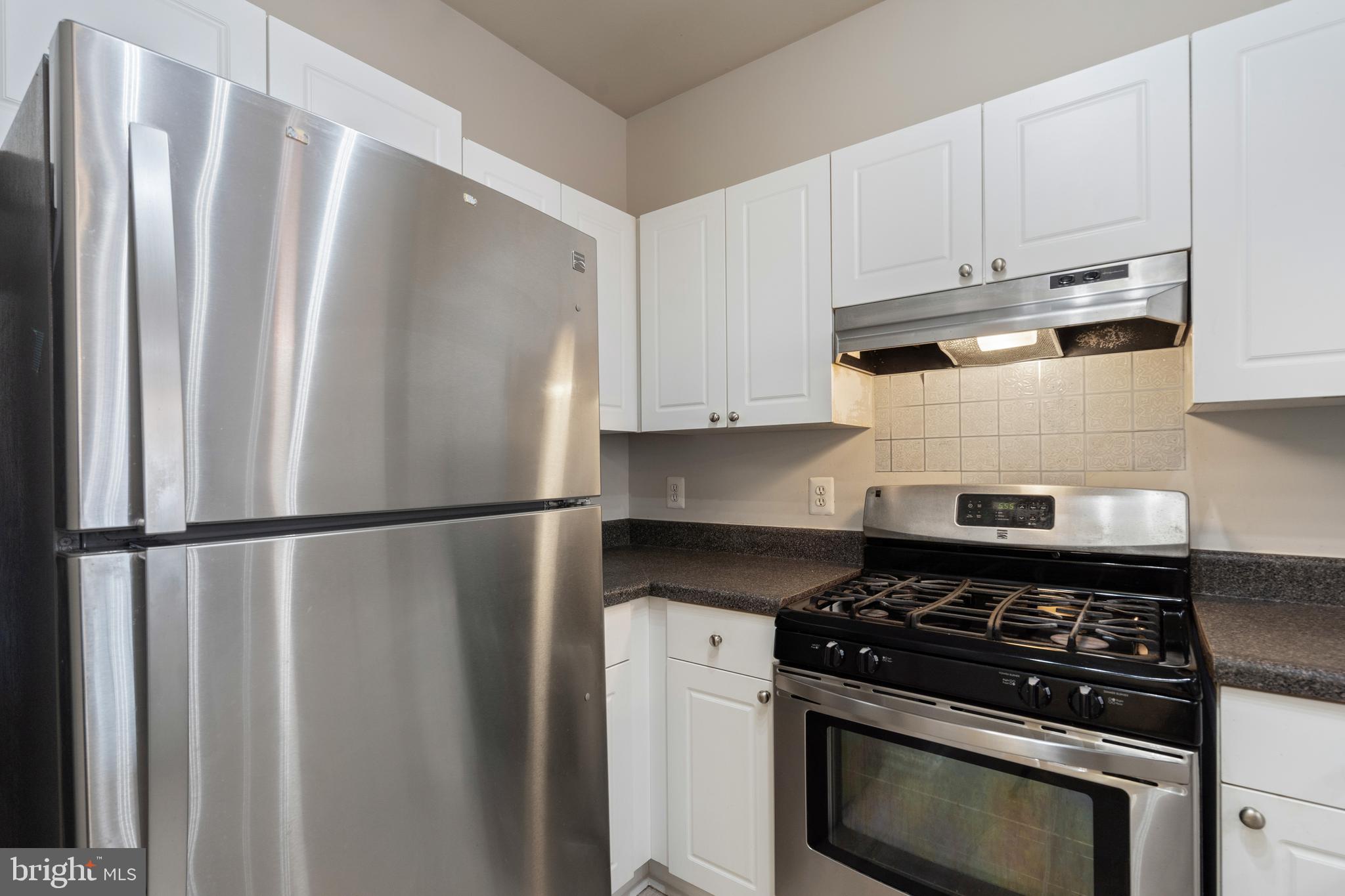 3851 Aristotle Court, Unit 1402 Fairfax, VA 22030 - Photo 10 of 31 a white refrigerator freezer and a stove sitting inside of a kitchen