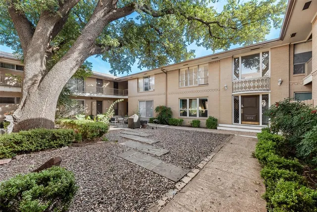 a front view of a house with garden and plants