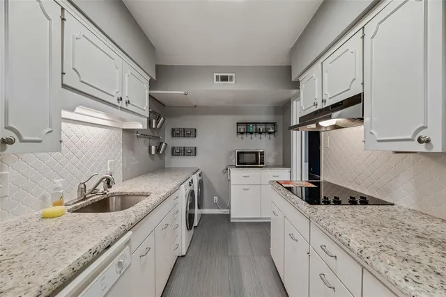 a kitchen with a sink dishwasher a stove top oven a refrigerator with wooden cabinets and floor