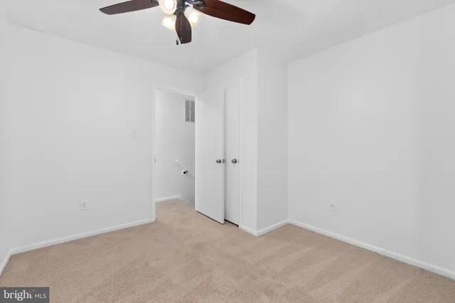 an empty room with a chandelier fan