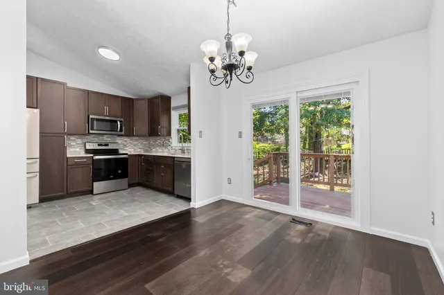 a kitchen with stainless steel appliances granite countertop a refrigerator a stove top oven a sink and dishwasher