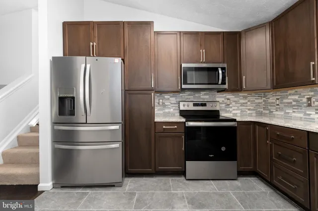 a kitchen with a refrigerator stove and microwave