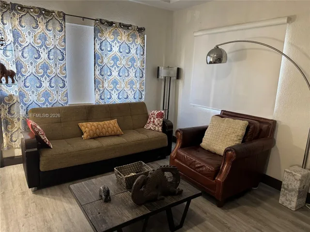 a living room with furniture and a painting on the wall