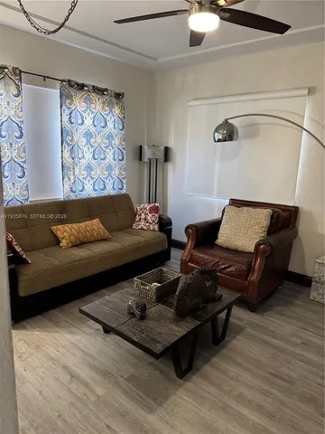 a living room with furniture and wooden floor