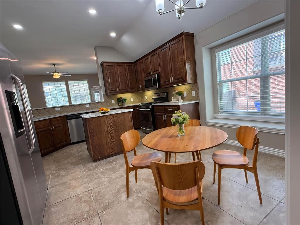 108 Cole Street Forney, TX 75126 - Photo 11 of 39 a kitchen with stainless steel appliances granite countertop a sink a stove a table and chairs