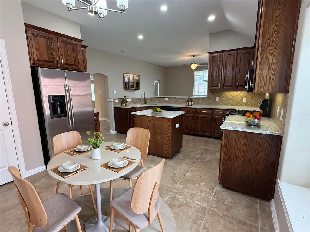 108 Cole Street Forney, TX 75126 - Photo 13 of 39 a kitchen with a table chairs stove a sink dishwasher and cabinets