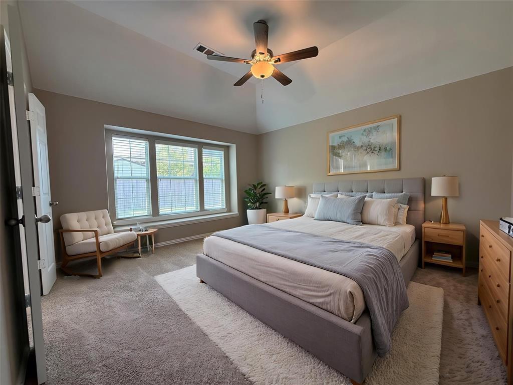 108 Cole Street Forney, TX 75126 - Photo 20 of 39 a spacious bedroom with a bed and a chandelier