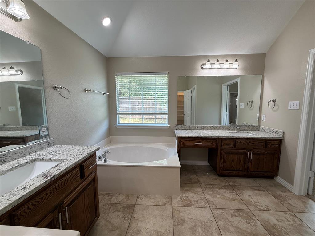108 Cole Street Forney, TX 75126 - Photo 26 of 39 a bathroom with a granite countertop sink a mirror and a bathtub