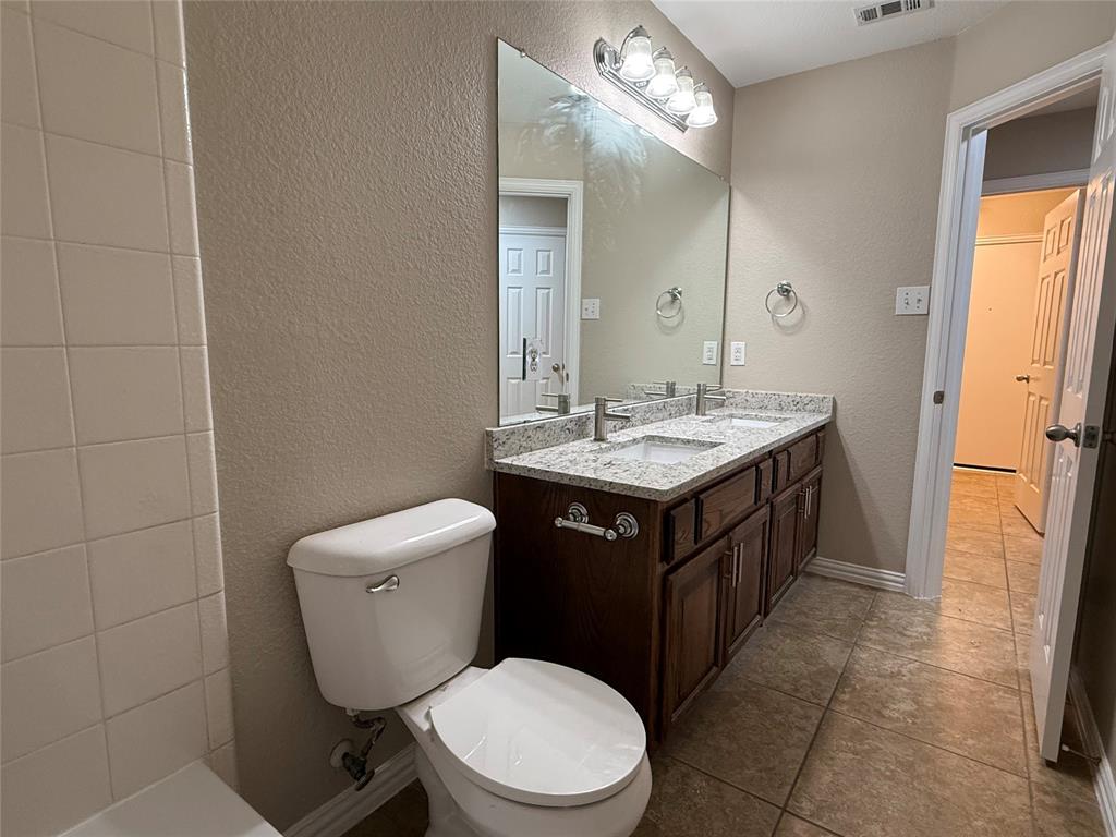 108 Cole Street Forney, TX 75126 - Photo 35 of 39 a bathroom with a toilet sink vanity and mirror