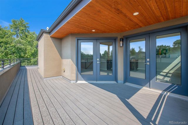 a bedroom with a bed and large windows