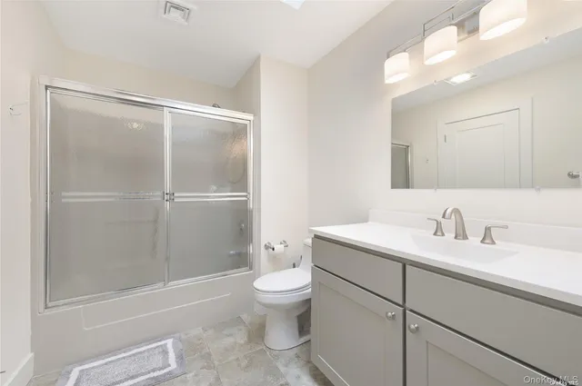 a bathroom with a granite countertop sink toilet and shower