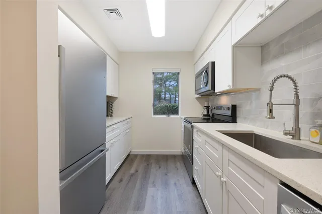 a kitchen with white cabinets and white appliances